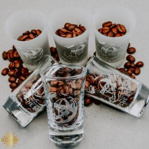 Lasergravuren sind permanent und weiß. Das Loge der Frechen Bohne ist auf alle Gläser graviert. Die Gläser sind mit Kaffeebohnen gefüllt. Es sind 4 cl Gläser. Jeweils drei satiniert und drei transparent.